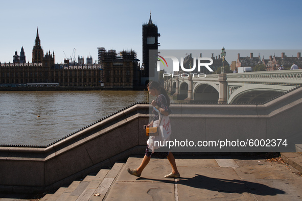 A woman walks down steps on the south side of Westminster Bridge, opposite the Houses of Parliament in London, England, on September 14, 202...