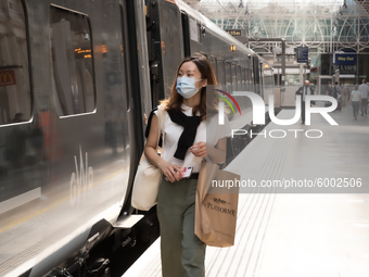 Passengers in protective face masks are seen at Paddington, London train station as the United Kingdom is experiencing a significant rise in...