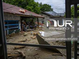 Residents leaning on their houses buried under mud due to flash floods in Rogo Village, Dolo Selatan District, Sigi Regency, Central Sulawes...