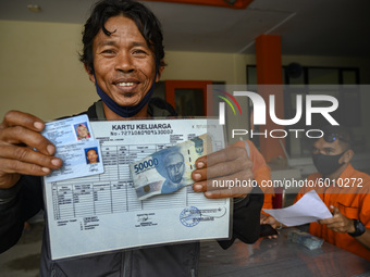 A resident shows the Cash Social Assistance (BST) money he just received at the Palu Post Office, Central Sulawesi Province, Indonesia on Se...