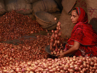 A woman sorting onions at a wholesale market in Dhaka, Bangladesh on September 19, 2020. (