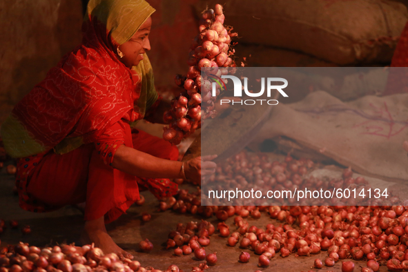 A woman sorting onions at a wholesale market in Dhaka, Bangladesh on September 19, 2020. 