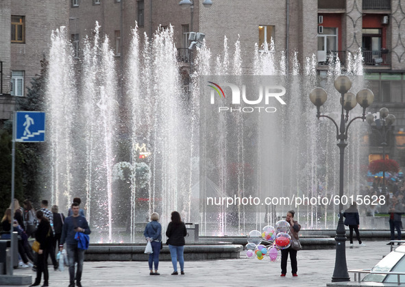 People walk next to a city fountain in the center of Kyiv, Ukraine on 19 September 2020. 