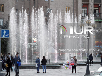 People walk next to a city fountain in the center of Kyiv, Ukraine on 19 September 2020. (