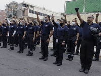 Rescuers and paramedics stood guard and held a minute of silence with raised fists outside the Rébsamen School in Mexico City, in memory of...
