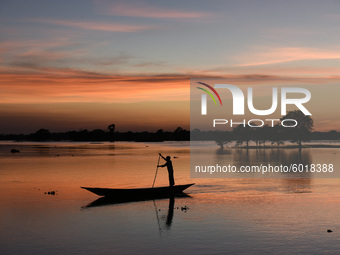 A man row his boat at sunset in a flood effected paddy field,  in a village in Barpeta district of Assam in India on 19 September 2020. (