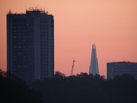 The Park Lane Hilton hotel (l) and Shard skyscraper (c) rise beyond the trees of Hyde Park at dawn in London, England, on September 22, 2020...