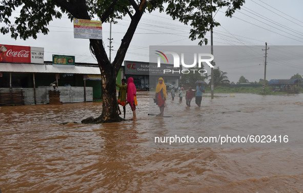 Commuters wade through a waterlogged street following heavy rainfall, at Boragaon in Guwahati, India on September 22, 2020.  
