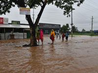 Commuters wade through a waterlogged street following heavy rainfall, at Boragaon in Guwahati, India on September 22, 2020.  (