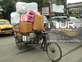 Labourers warring face mask  push a cycle van loaded Goods on the Street in Kolkata,India on Tuesday, September 22,2020. The nation of 1.3 b...
