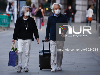 An elderly couple wearing face masks walk along Regent Street in London, England, on September 22, 2020. British Prime Minister Boris Johnso...