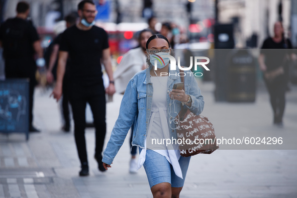 A woman wearing a face mask walks along Regent Street in London, England, on September 22, 2020. British Prime Minister Boris Johnson this a...