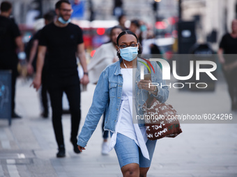 A woman wearing a face mask walks along Regent Street in London, England, on September 22, 2020. British Prime Minister Boris Johnson this a...