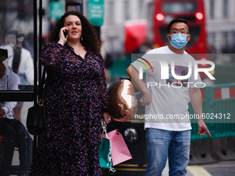 A man wearing a face mask waits at a bus stop on Regent Street in London, England, on September 22, 2020. British Prime Minister Boris Johns...