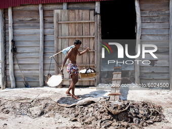 Portrait of the workers of the Kampot salt pans, during the collection of salt that is transported in baskets weighing twenty or thirty kilo...