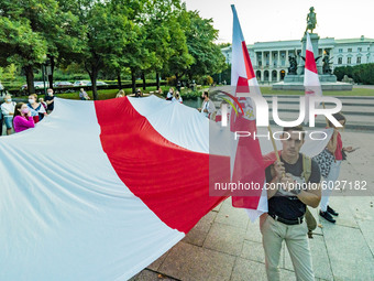 Protester holds a huge  old belarusian flag, symbol against the current Belarus government, during a demonstration in Warsaw, Poland, on Sep...