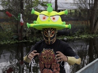 Dagma, a member of Chinampaluchas, on board a boat wears a hat with the figure of the coronavirus during a wrestling function in Chinampa on...