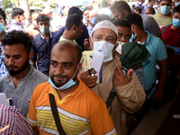 Bangladeshi migrant workers who work in Saudi Arabia gather in front of the Biman Bangladesh Airlines office to collect air tickets to go ba...
