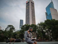 A woman wear protective face mask read a book in Central Business District in Jakarta on Friday 25 September 2020. For the third day in a ro...