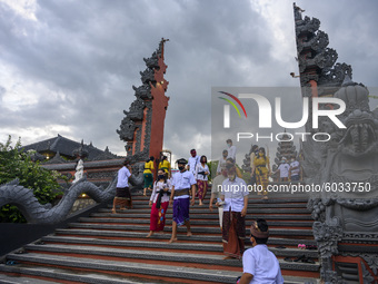 Hindus walk out after participating in the Kuningan Day prayer ritual at Pura Agung Wana Kerta Jagatnatha, Palu, Central Sulawesi Province,...