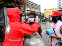 Volunteer of Bangladesh Red Crescent Society distribution facemak to Pedestrians for using during the Covid-19 Coronavirus pandemic in Dhaka...