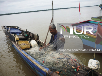 A fisherman is releasing his catch from his net in Sungsang, Banyuasin Regency, South Sumatra on Saturday, September 26, 2020. (