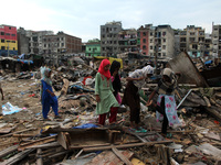 Residents are seen outside demolished slum dwellings after demolition drive by the Delhi Development Authority (DDA) against encroachments a...