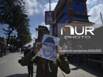 Nepalese Police along with PPE catch the youths as they arrive along with a printed portrait mask of Prime Minister KP Sharma Oli during a d...