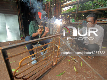 A girl works at a fabrication shop as she is welding iron grills to earn money to maintain her livelihood after lockdown relaxation in betwe...