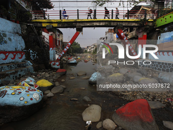 People are seen crossing over the a bridge at the Ciliwung river in Bogor, West Java, 27 September 2020. World Rivers Day (WORD) is celebrat...