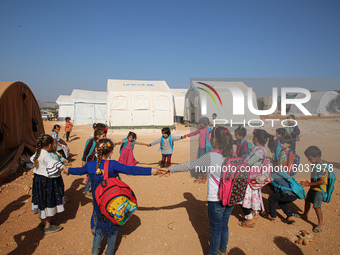 Syrian students play in front of their school tent on the first day of the new school year near the city of Maarat Misreen in Idlib countrys...