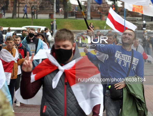 People carry historical white-red-white flags of Belarus during a rally of solidarity with Belarusian protests in Kyiv, Ukraine on 27 Septem...
