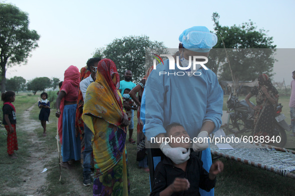 A health worker in personal protective equipment (PPE) collects a nasal swab samples from locals for Covid-19 Rapid Antigen Testing (RAT), n...