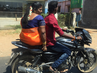 Husband and wife ride on a motorbike in Chunkan Kadai, Alur, Tamil Nadu, India on February 12, 2020. (