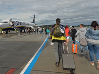 Passengers boarding a Ryanair plane at John Paul II Krakow-Balice International Airport.
Ryanair plans to cut another one in five flights sc...