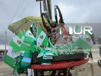 A woman selling Nigerian flags reacts as she display flags for pass by, at Allen roundabout in Ikeja, ahead of Nigeria 60th Independence Day...