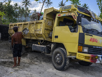 Workers shovel sand onto trucks in a traditional sand mining area in Kotapulu Village, Sigi Regency, Central Sulawesi Province, Indonesia on...