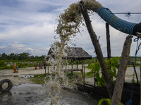 Residents pass near a sand shelter in a traditional sand mining area in Kotapulu Village, Sigi Regency, Central Sulawesi Province, Indonesia...