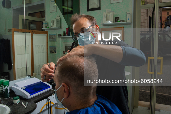 The work of small and medium artisans during the coronavirus emergency, in their small shops.
In the photo a barber , in Rieti, Italy, on Oc...