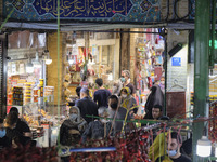 Iranian people wearing protective face masks walk in a bazaar in northern Tehran while the new coronavirus (COVID-19) disease rapid rising i...