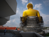 Buddhist devotees walk through a giant Buddha statue under construction at Wat Paknam Bhasi Charoen temple on October 6, 2020 in Bangkok, Th...