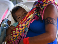 A woman from the indigenous Guajajara ethnic group is seen holding her child while waiting for medical care,  amid the Coronavirus (COVID-19...