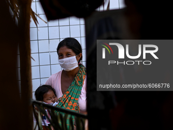 A woman from the indigenous Guajajara ethnic group is seen holding her child while waiting for medical care, amid the Coronavirus (COVID-19)...