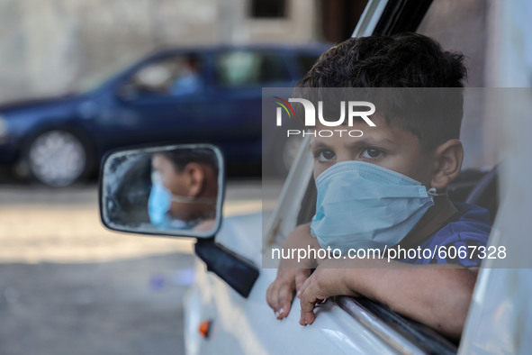 A child mask-clad due to the Covid-19 coronavirus pandemic, looks at the street in Gaza city,on October 8, 2020.
 