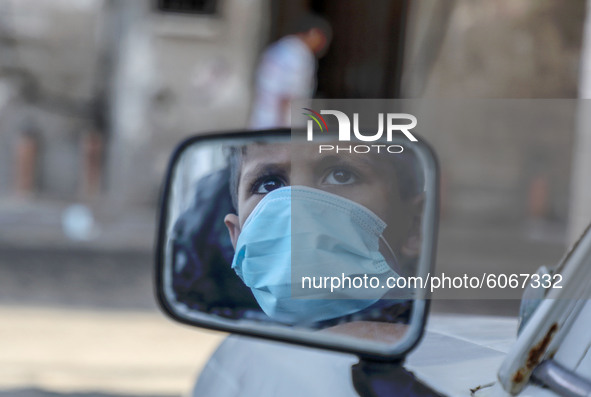 A child mask-clad due to the Covid-19 coronavirus pandemic, is reflected in a mirror at a street in Gaza city,on October 8, 2020.
 