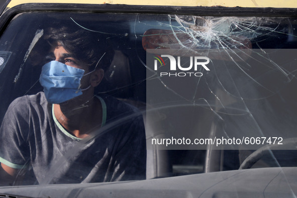 A young Palestinian man looks from behind the windows of a car in Gaza City, on October 8, 2020. 