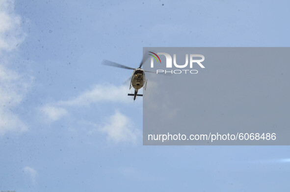 A surveillance helicopter hovers above the central Bank of Nigeria in Akure, as INEC Officials commenced the distribution of electoral mater...