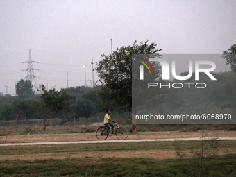 A boy cycles along the field near Rainy Well at ITO on October 8, 2020 in New Delhi, India. (
