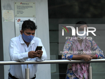 Bank employees wear masks as a precautionary measure against Covid-19, outside a bank during lunch break at Preet Vihar on October 8, 2020 i...