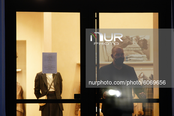 A security guard at an upscale clothing retail store is seen in Warsaw, Poland on October 8, 2020. The ministry of health on Thursday announ...